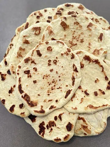 Soft homemade flatbread, perfect for wraps, dips, or as a side, cooked until golden brown