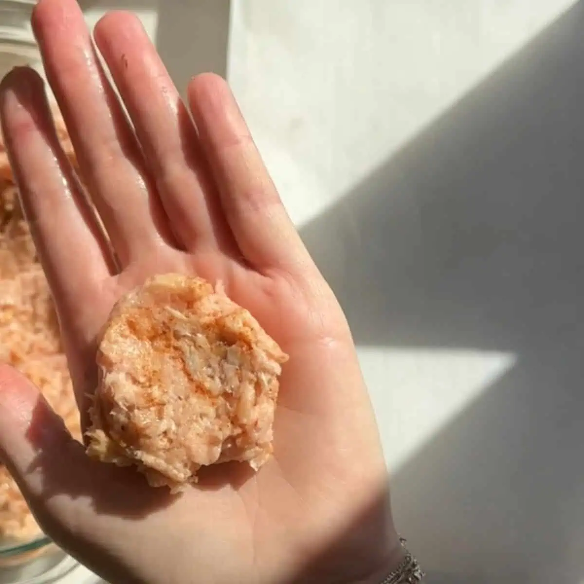 Hand shaping homemade chicken nugget mixture into patties