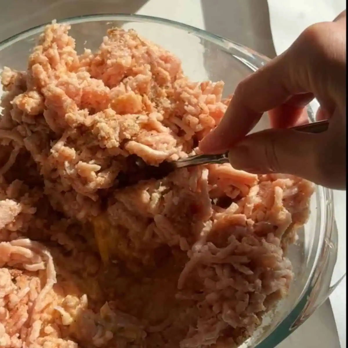 Ingredients for homemade baked chicken nuggets mixed together in a mixing bowl. 