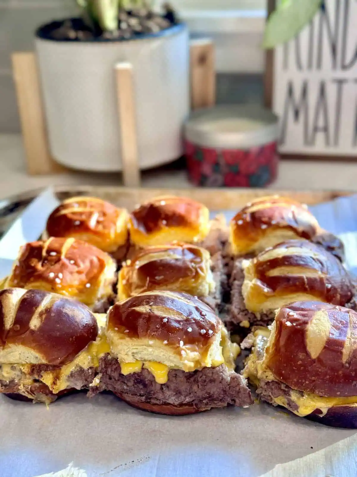 Perfectly baked pretzel bun cheeseburger sliders, fresh and ready to serve.