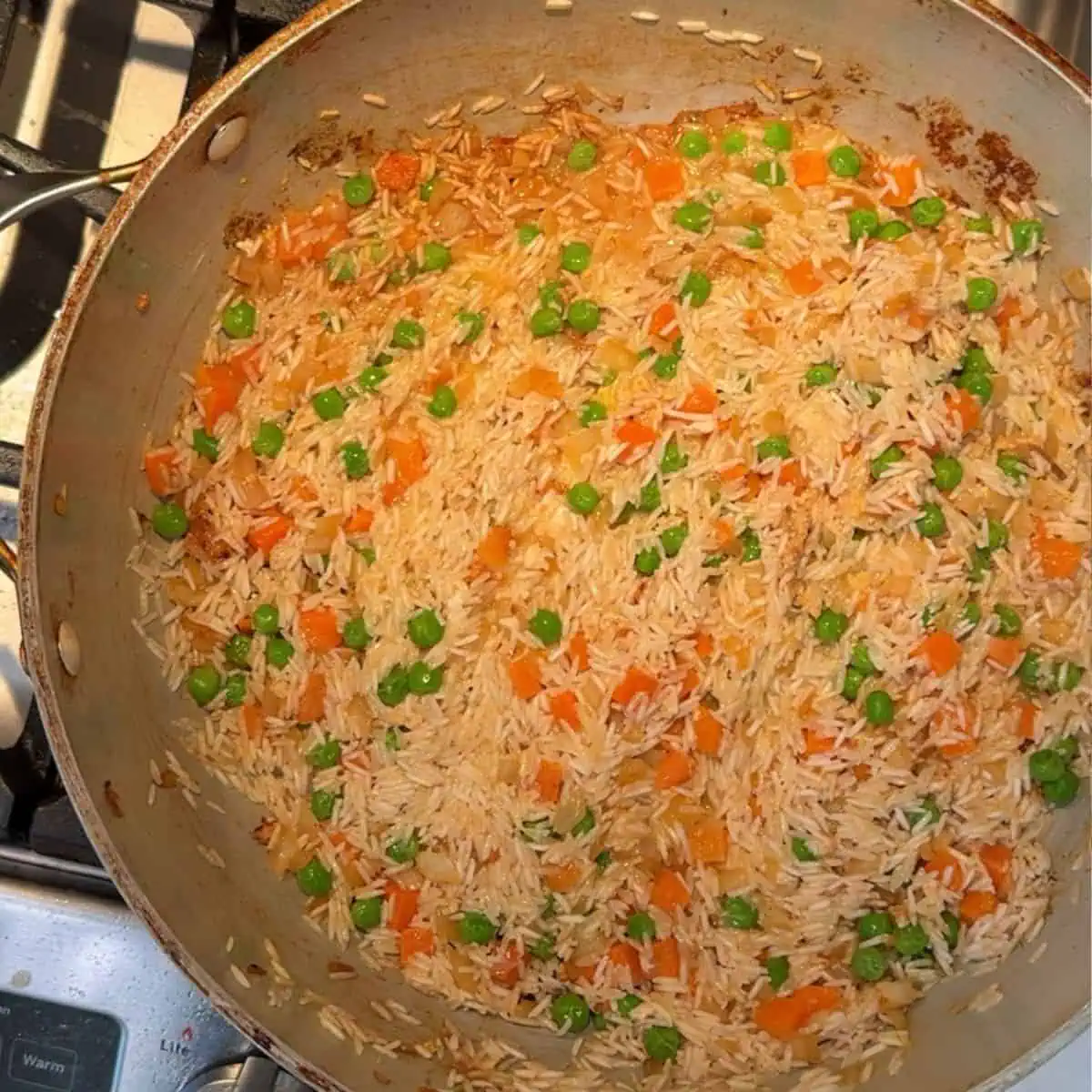 Rice, peas, carrots, onions in the pan after the chicken is removed. 