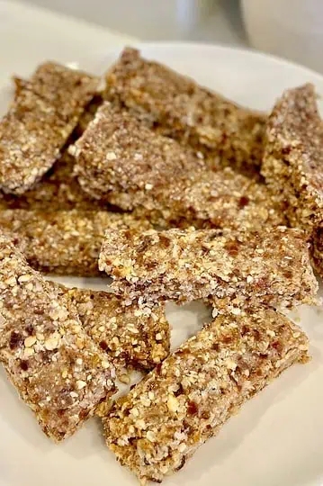 A close-up shot of a stack of freshly cut granola bars, highlighting their texture and ingredients.