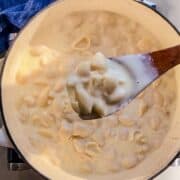 A Dutch oven filled with creamy, homemade mac and cheese, with a rich cheese sauce coating every pasta shell.
