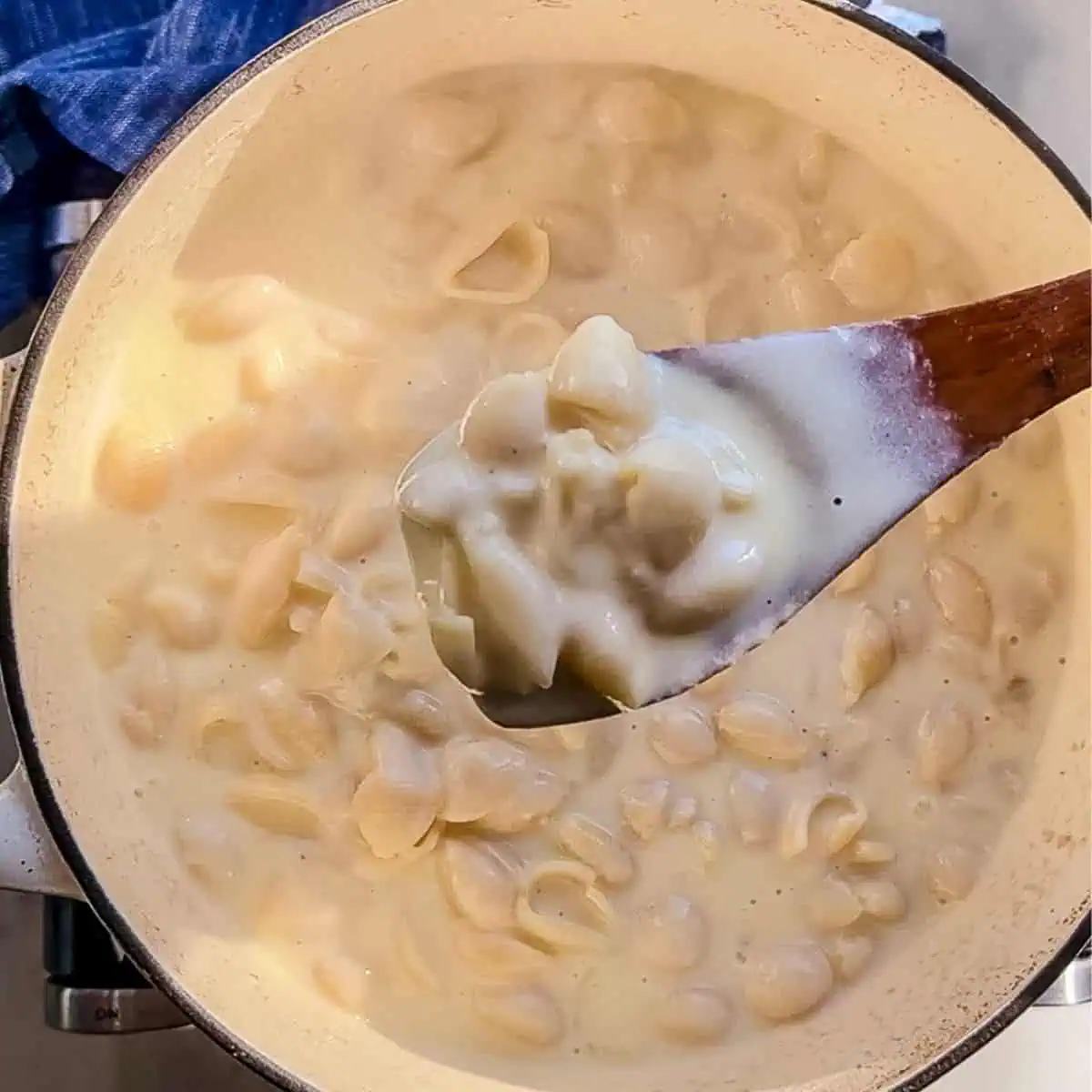 A Dutch oven filled with creamy, homemade mac and cheese, with a rich cheese sauce coating every pasta shell.