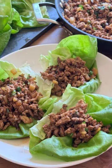 Multiple chicken lettuce wraps assembled on a platter, ready to serve