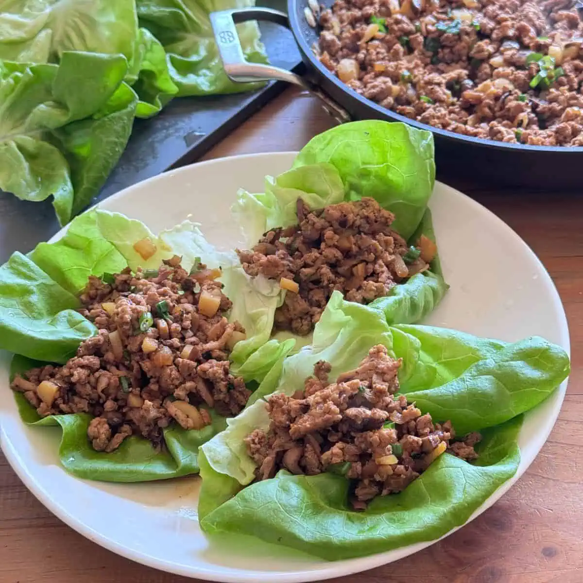 Multiple chicken lettuce wraps assembled on a platter, ready to serve