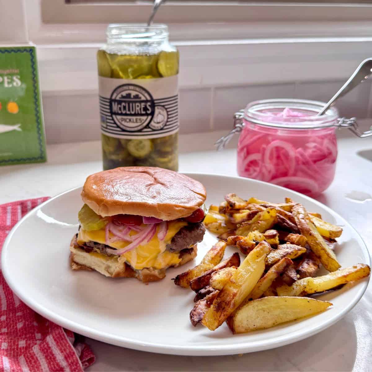 Smash burger plated with crispy homemade fries, ready to serve.