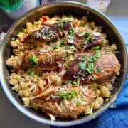 Close-up of creamy sun-dried tomato chicken and pasta topped with grated Parmesan and fresh parsley.