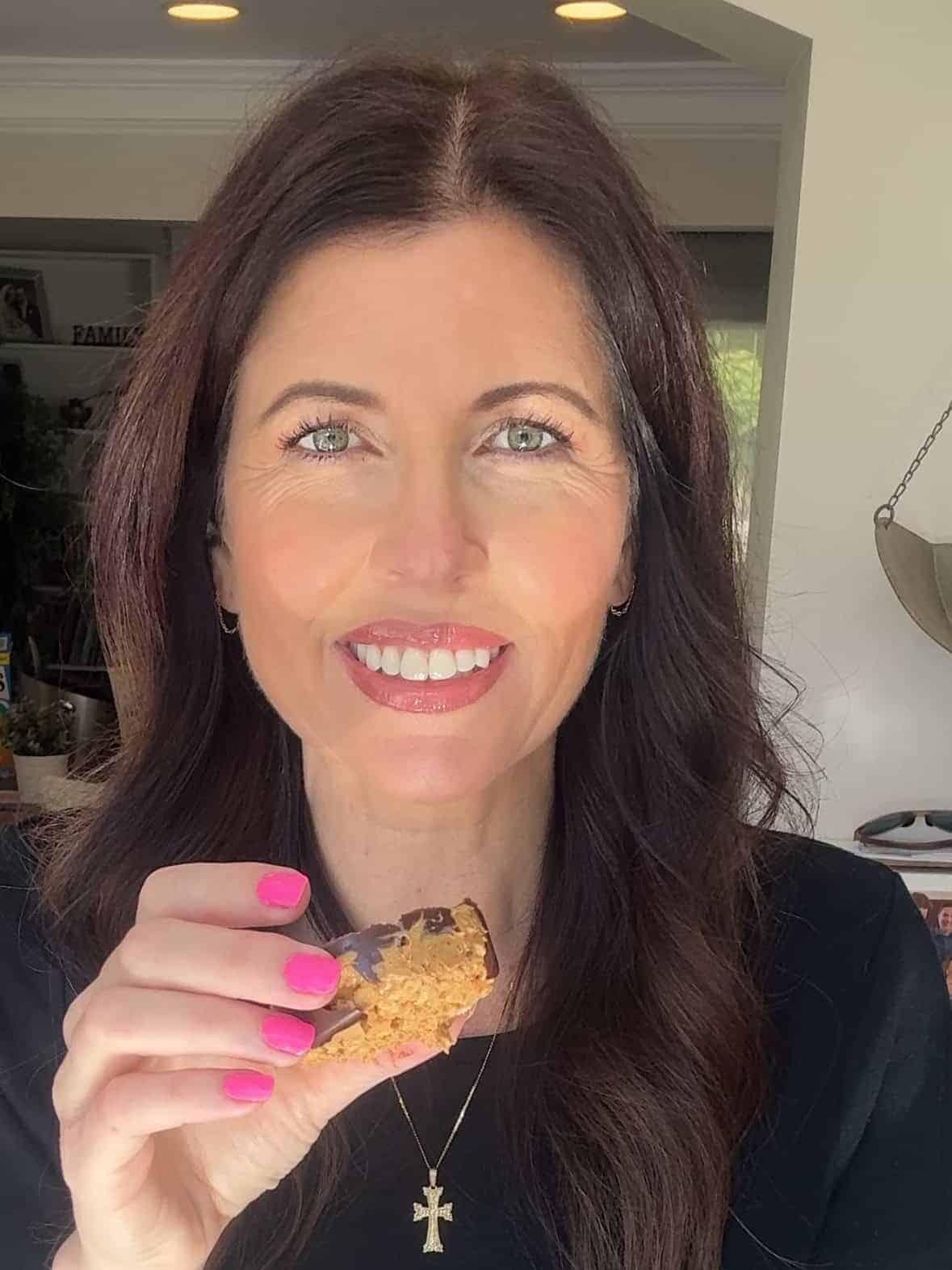 Protein peanut butter rice cake cup in hand after bite was taken out of it.