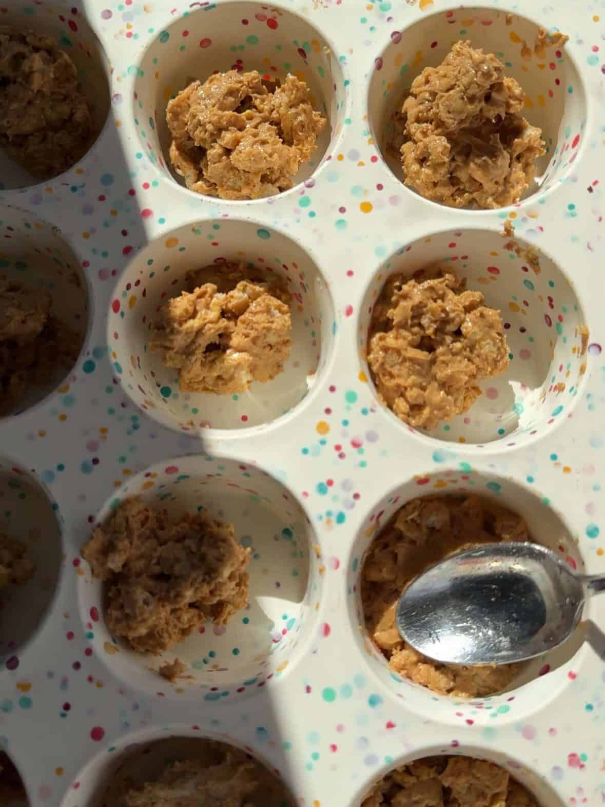 Mixture of peanut butter and crushed rice cakes pressed into silicone cupcake molds.