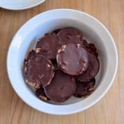 Bowl filled with protein peanut butter rice cake cups topped with dark chocolate and sea salt flakes.