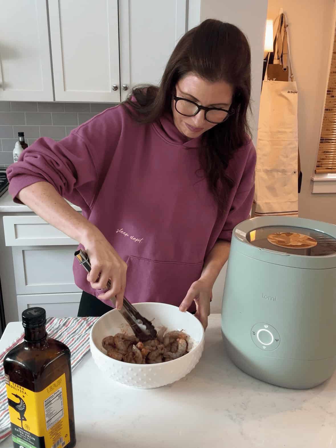Raw shrimp being seasoned in a white bowl with spices for steak and shrimp hibachi bowls, a hibachi-style stir-fry recipe made at home.