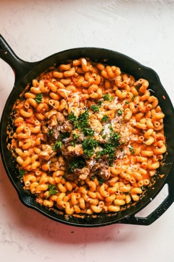 Overhead view of easy blush pasta with chicken thigh bites topped with Parmesan and parsley
