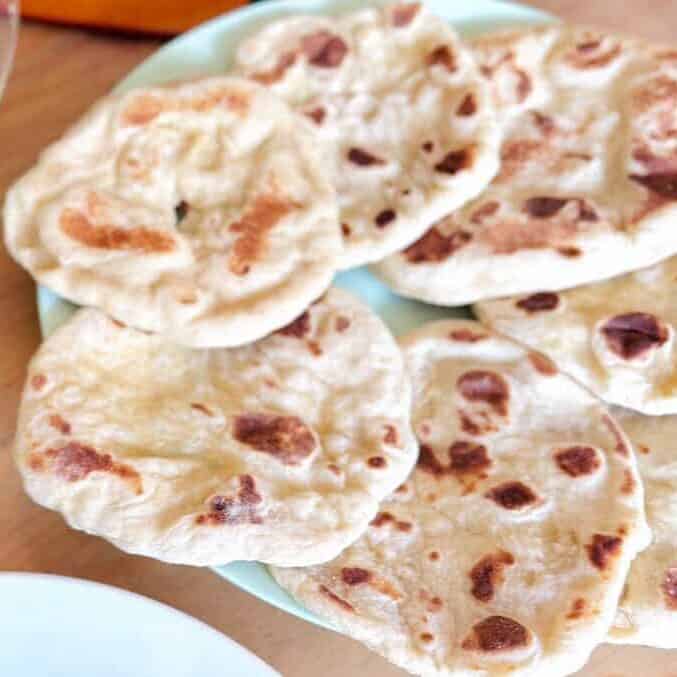 Soft homemade sweet flatbread on a plate with a fresh salad in the background, similar to Olga bread
