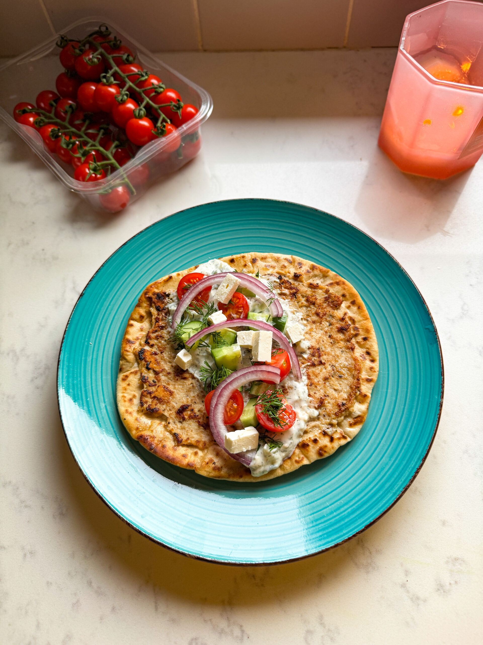 Greek smashed chicken taco surrounded by fresh Mediterranean toppings