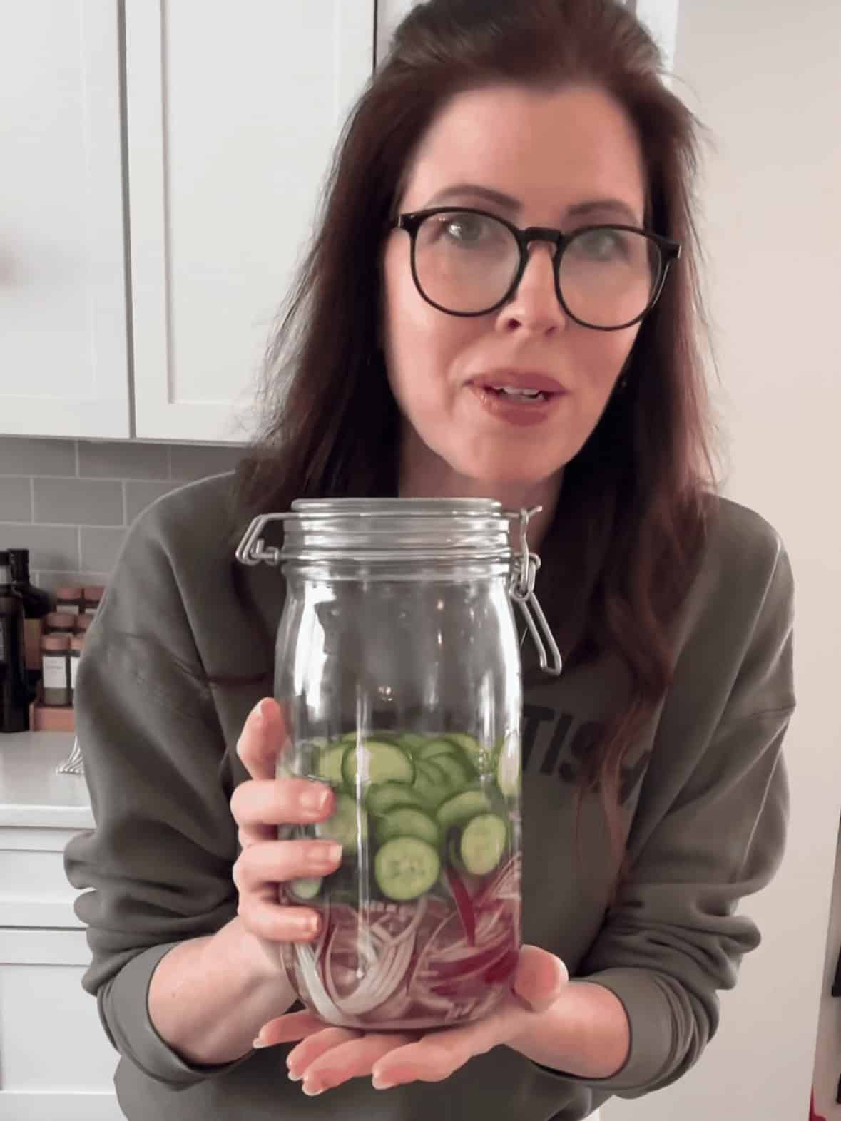 Close-up of mason jar filled with quick pickled red onions and cucumbers