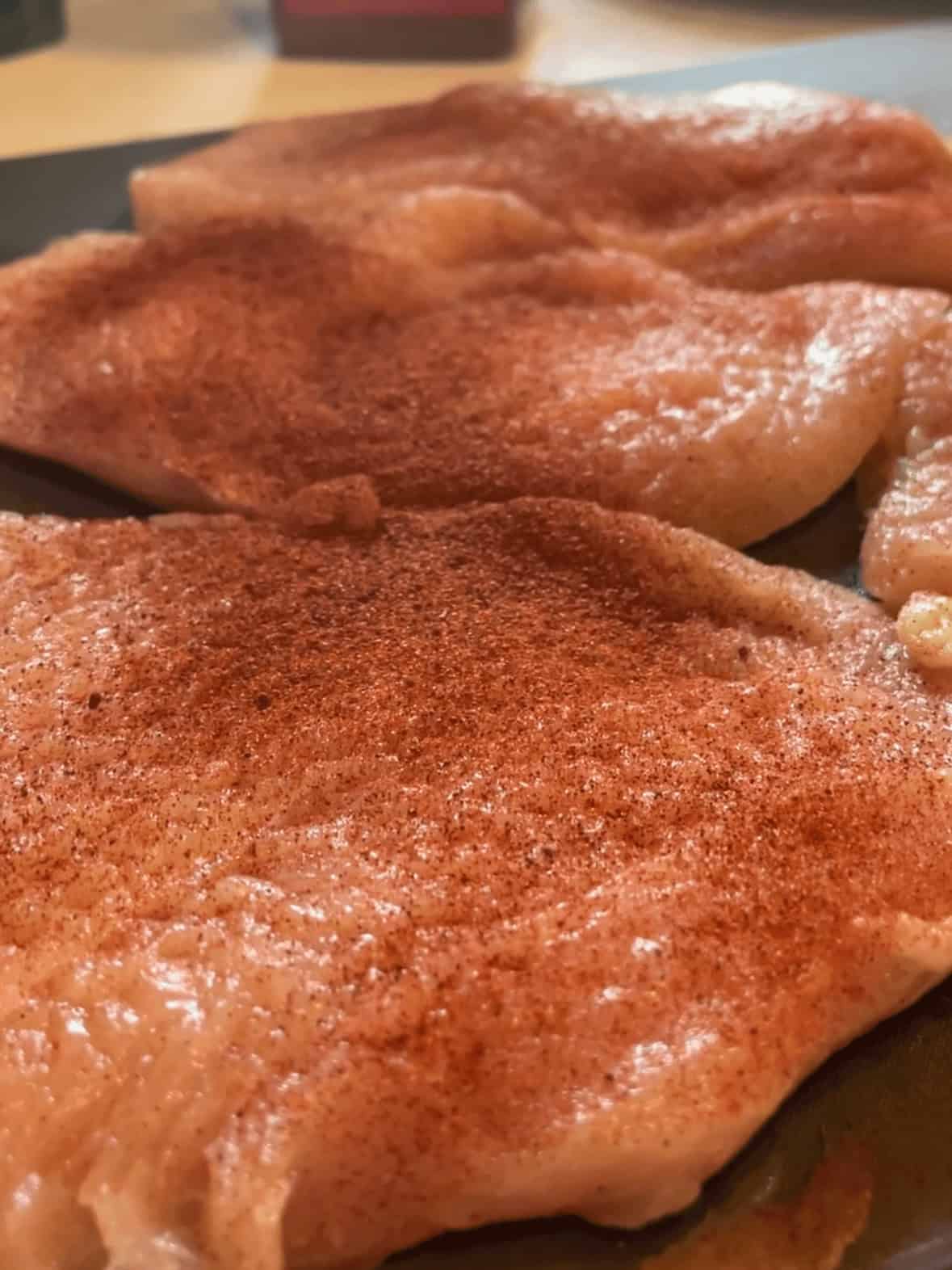 Chicken breasts being pounded thin for garlic parmesan chicken pasta