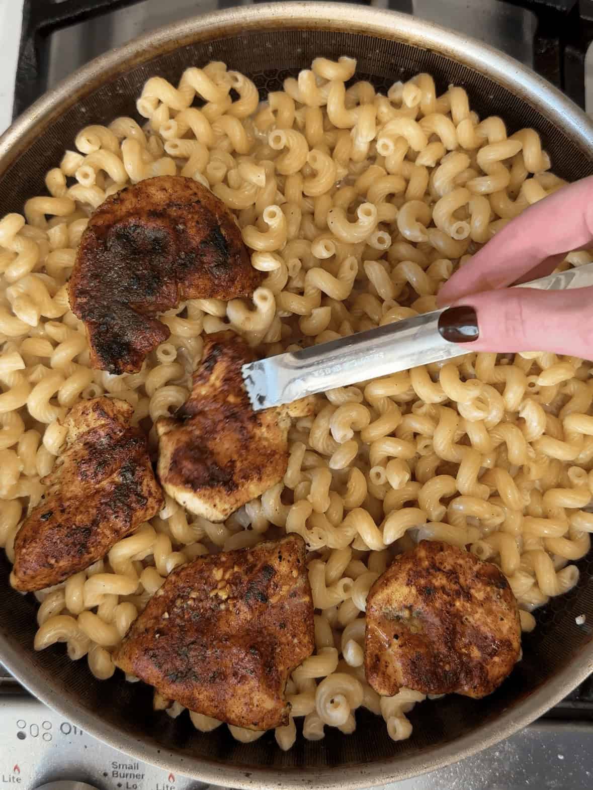 Adding chicken back to creamy garlic parmesan chicken pasta in the skillet