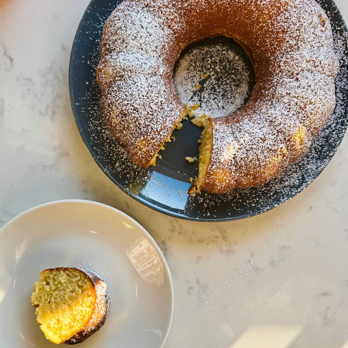 Overhead view of olive oil Bundt cake with a slice on a white plate