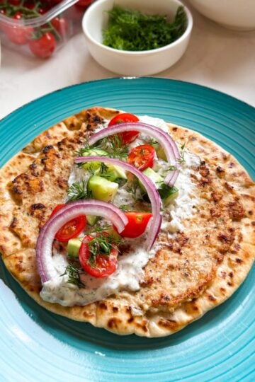 Greek smashed chicken taco surrounded by fresh Mediterranean toppings