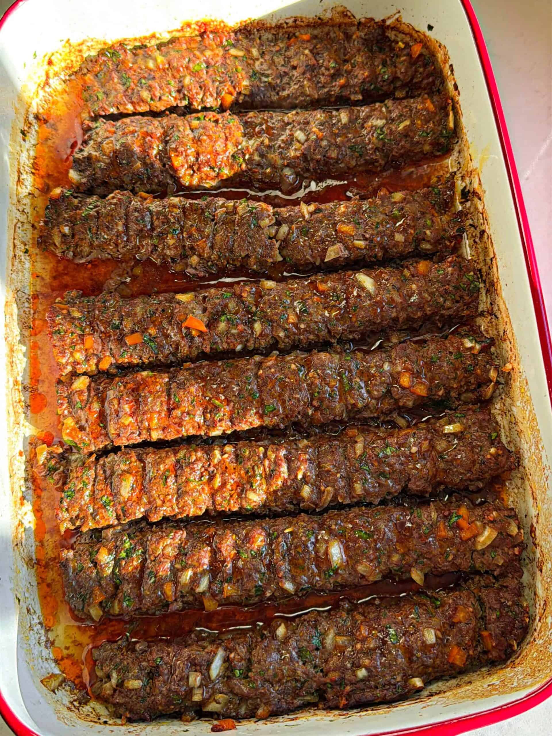 Finished oven baked ground beef kofta in casserole dish with caramelized edges after broiling