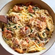 Overhead view of shrimp and spinach pasta with roasted red peppers and parmesan cheese