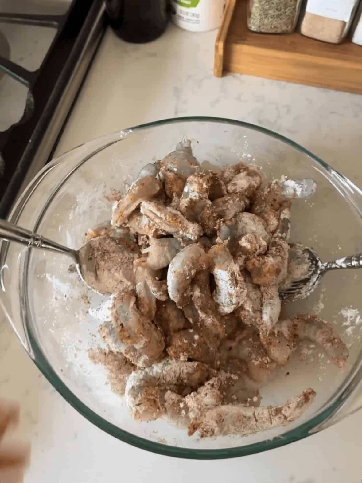 Seasoning raw shrimp with cornstarch paprika and garlic powder for shrimp pasta
