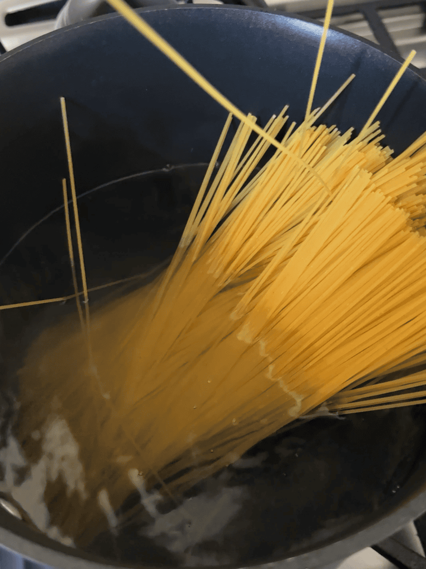 Cooking spaghetti in boiling water for shrimp pasta with spinach recipe