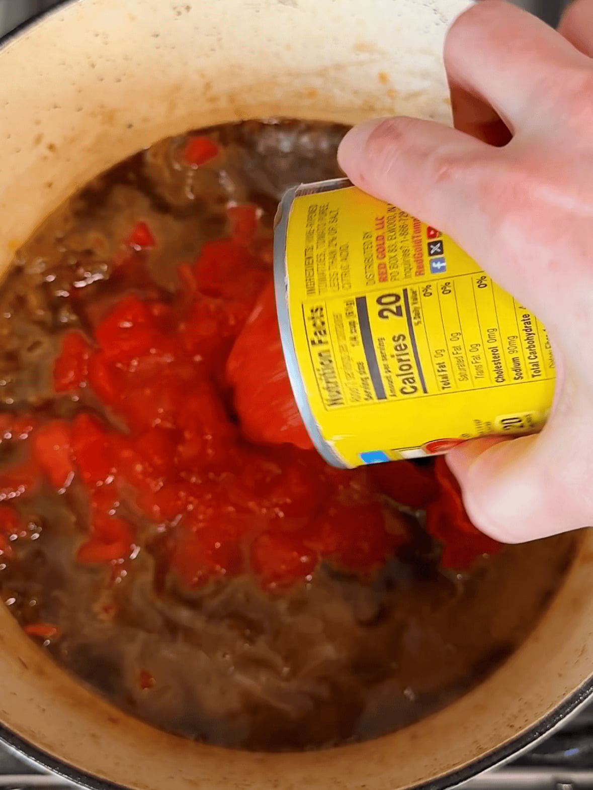 Step 3 pouring crushed tomatoes into pan for creamy tomato chicken pasta sauce