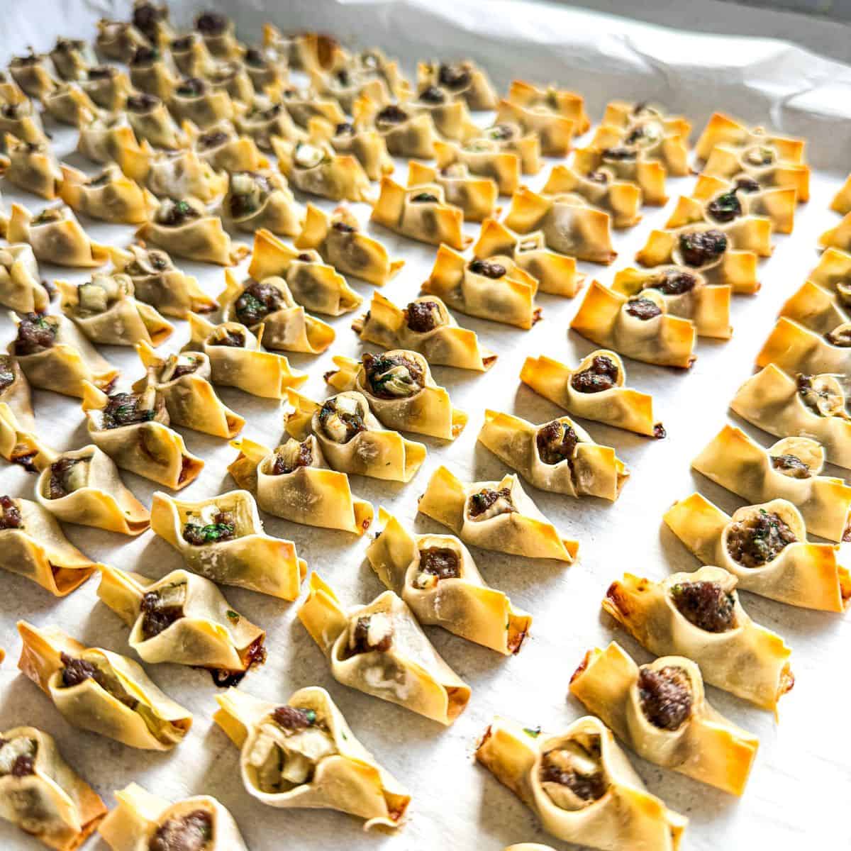 Golden baked Armenian Manti dumplings on a tray made with wonton wrappers and seasoned ground sirloin.