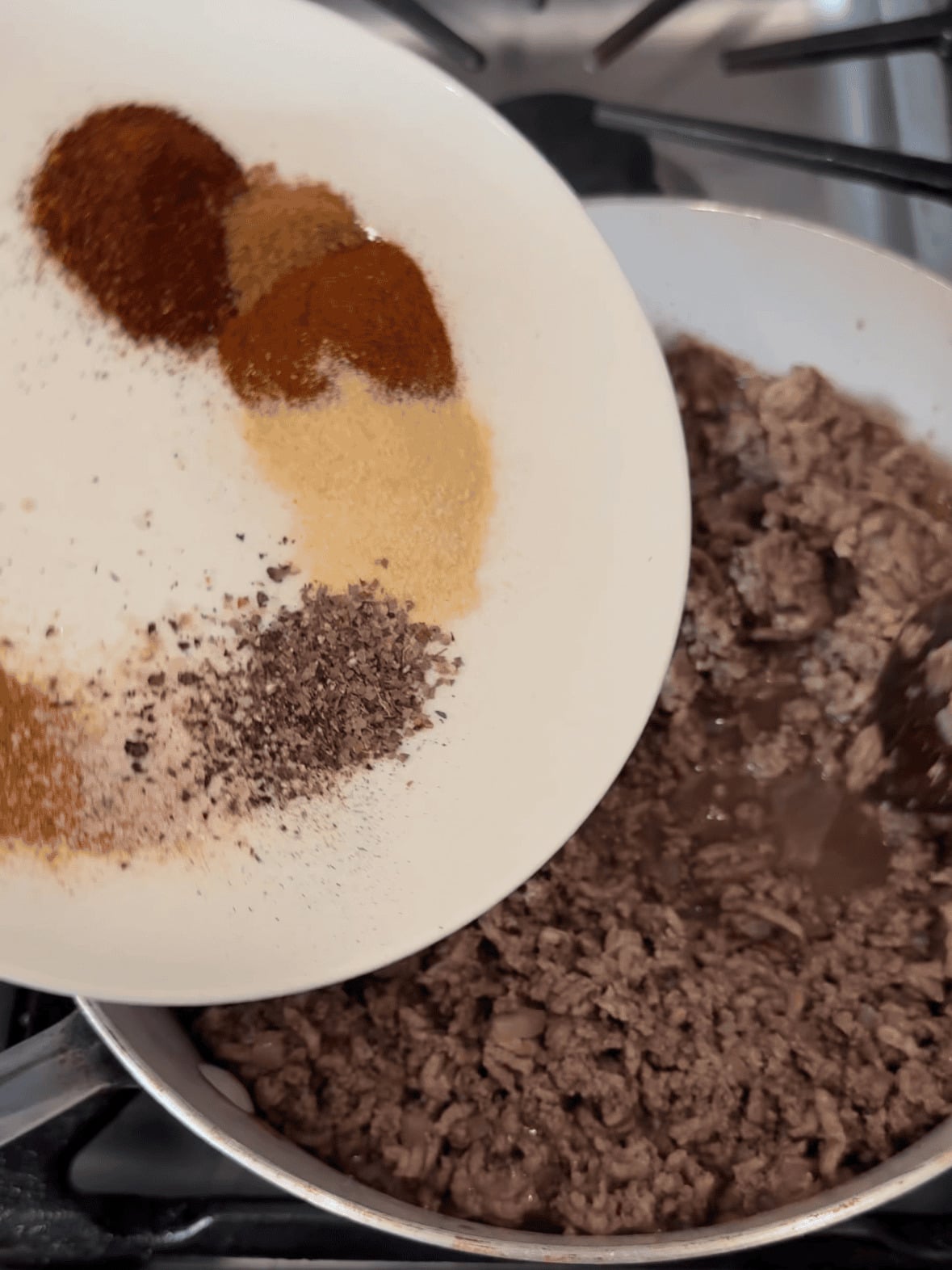 adding taco seasoning to ground beef for baked ground beef tacos recipe