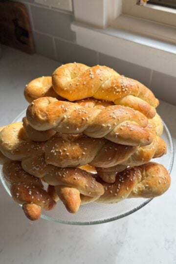 Close up of cheoreg Armenian sweet bread twists with sesame seeds on a glass cake stand