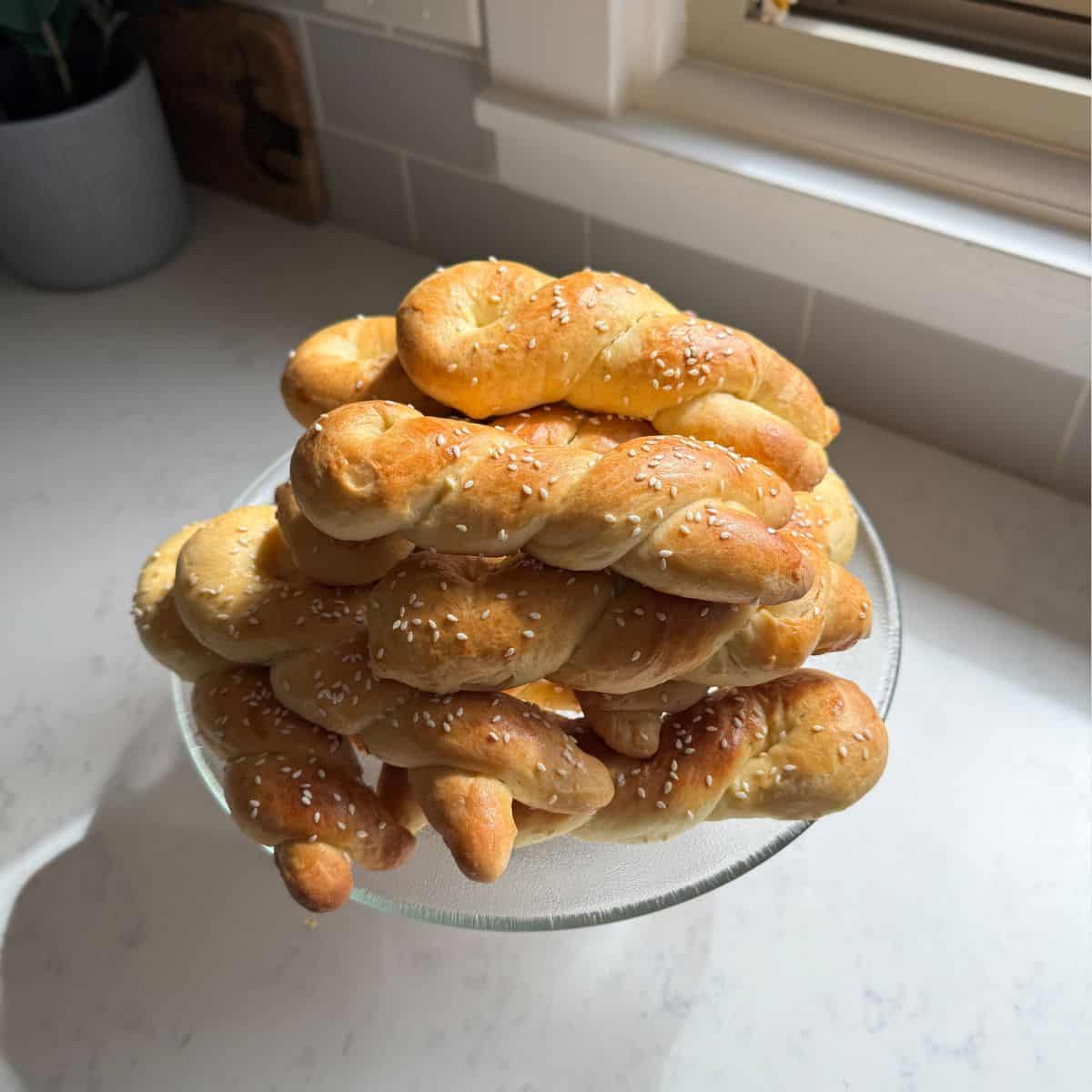 Close up of cheoreg Armenian sweet bread twists with sesame seeds on a glass cake stand