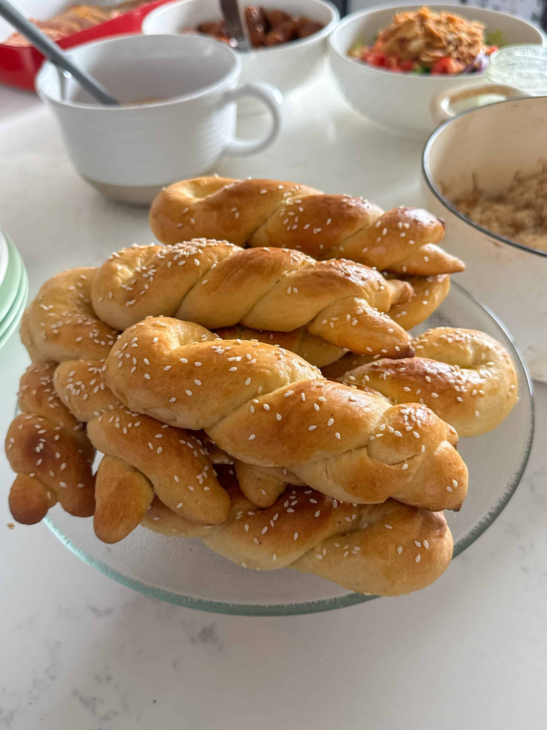 Cheoreg choreg Armenian Easter bread on a glass cake stand surrounded by a holiday spread
