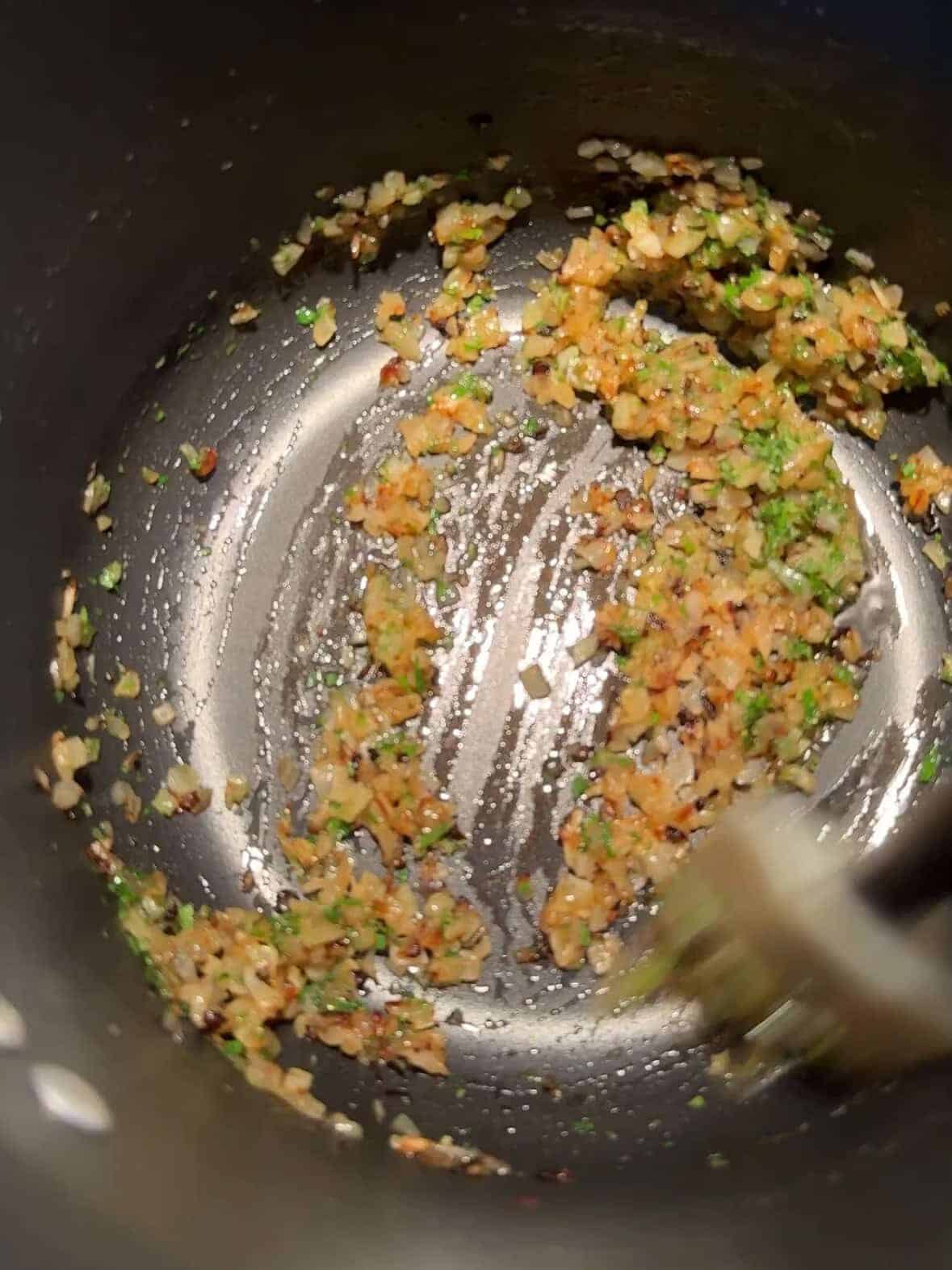 Finely chopped onions softening in olive oil in a large soup pot, first step in making tutmaj abour
