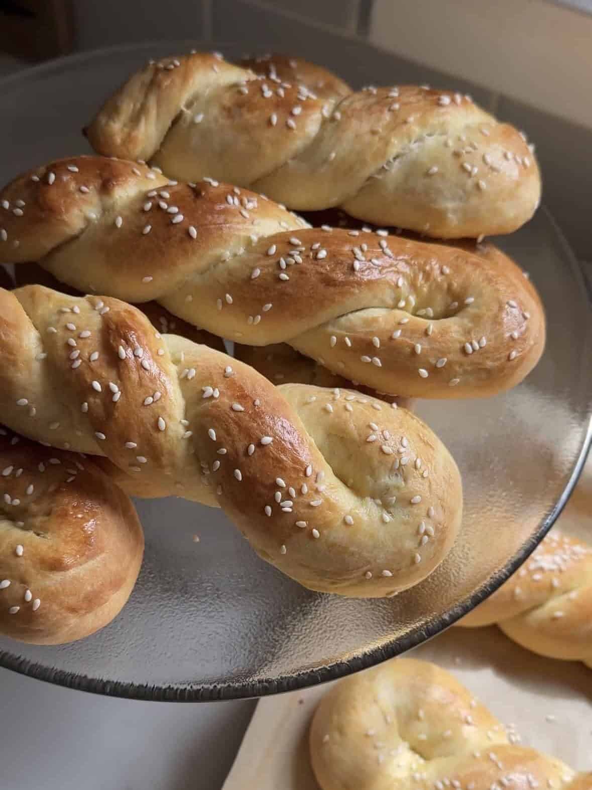 Close up of cheoreg Armenian sweet bread twists with sesame seeds on a glass cake stand