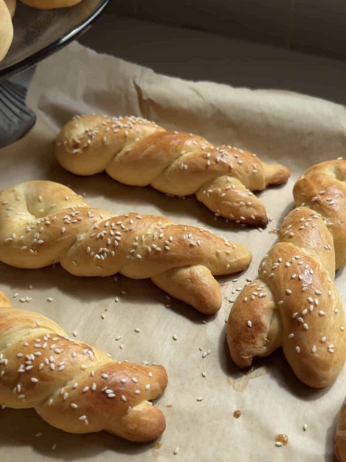Cheoreg choreg twists with sesame seeds cooling on parchment paper in warm light