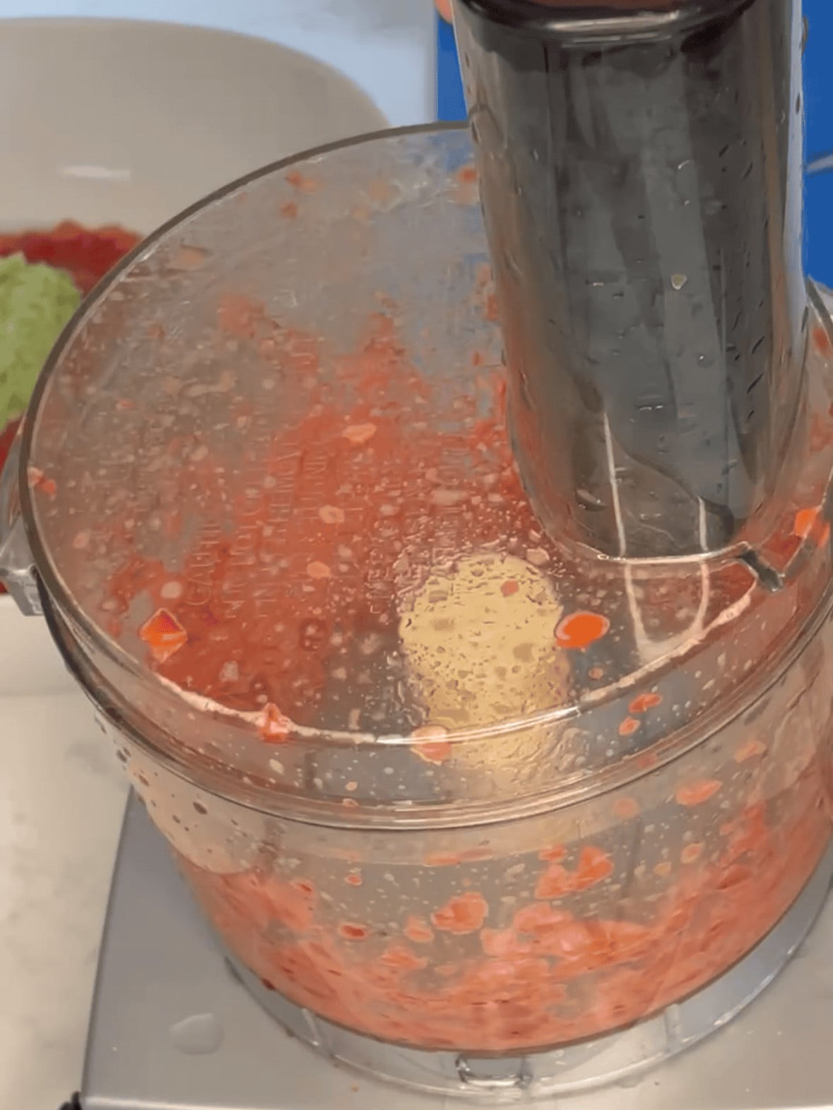 Chopped onions, tomatoes, green peppers, and fresh parsley in a food processor before blending for Armenian lahmajoun meat filling.