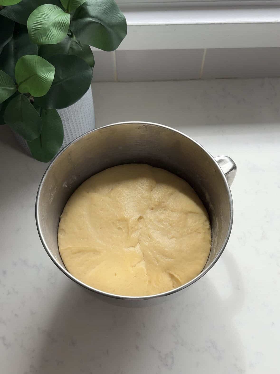 Cheoreg dough doubled in size in a silver stand mixer bowl after rising