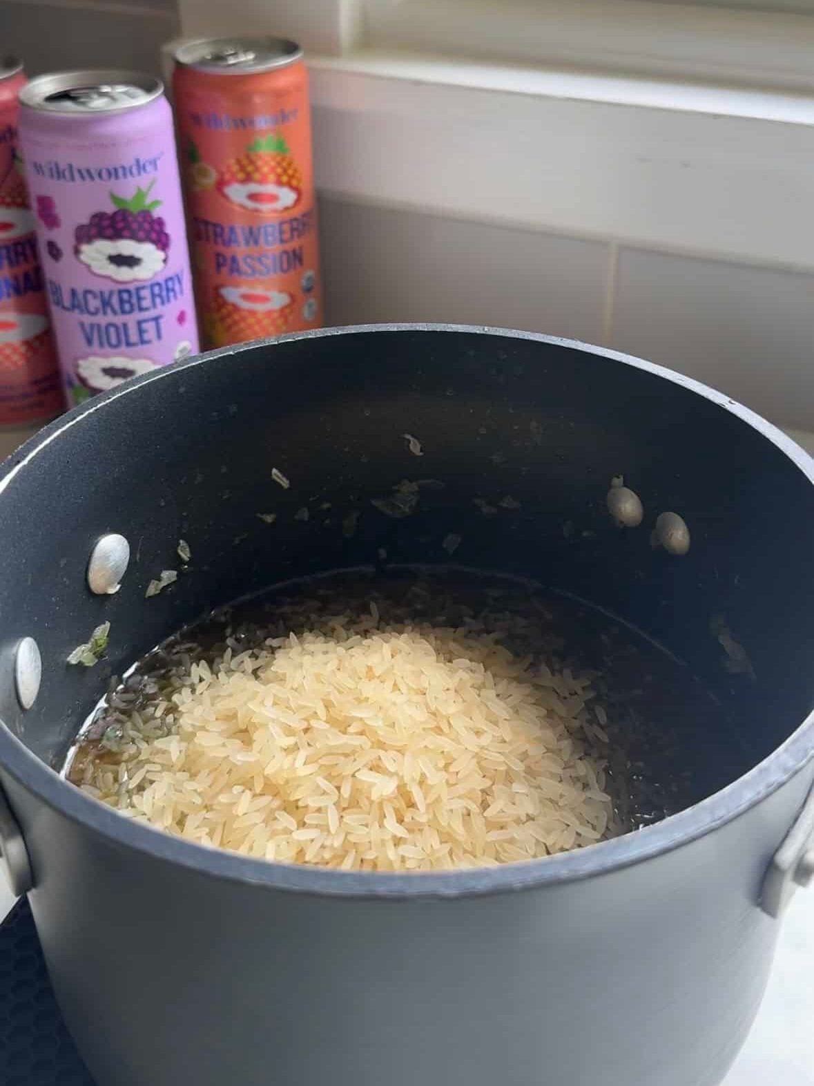 Pot of white rice with herbs simmering for stuffed grape leaf filling
