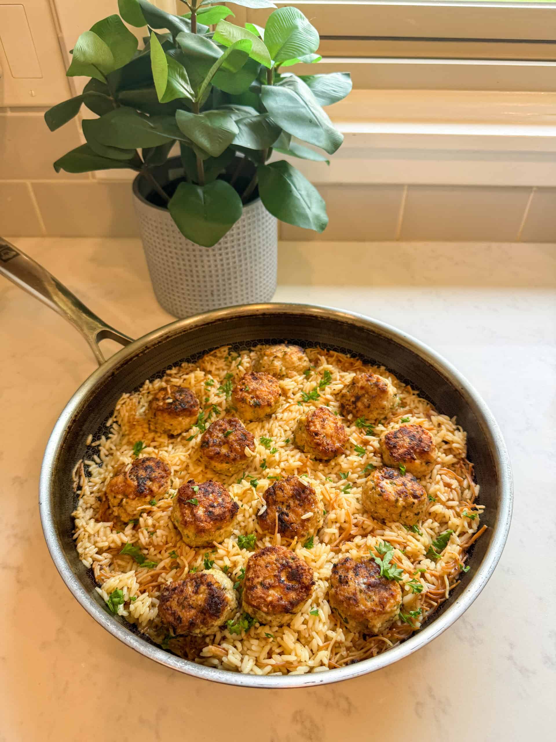 Close-up of seared Greek chicken meatballs over rice pilaf with herbs