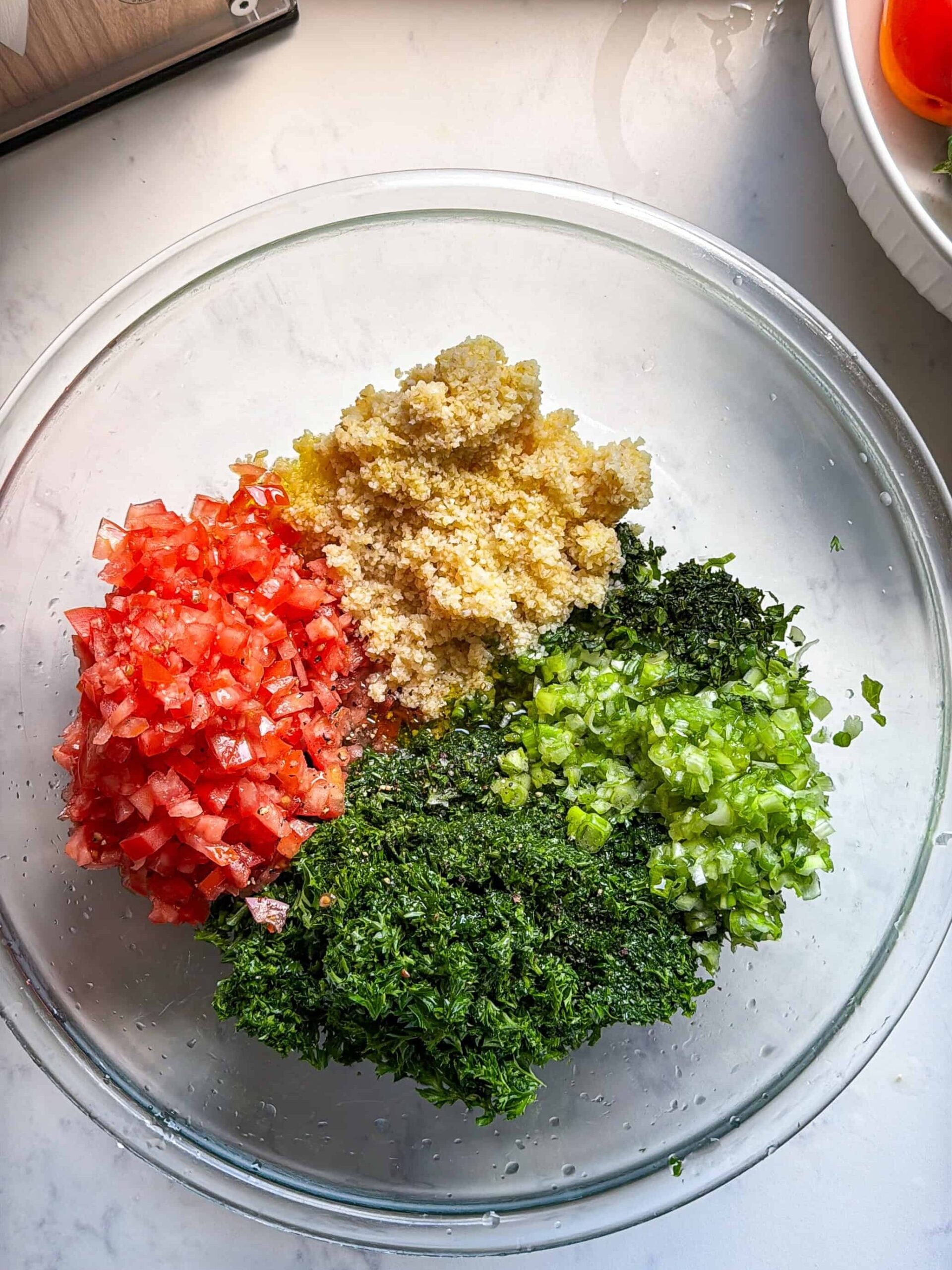Tomatoes, bulgur, parsley, and green onion arranged separately before mixing Levantine tabbouleh