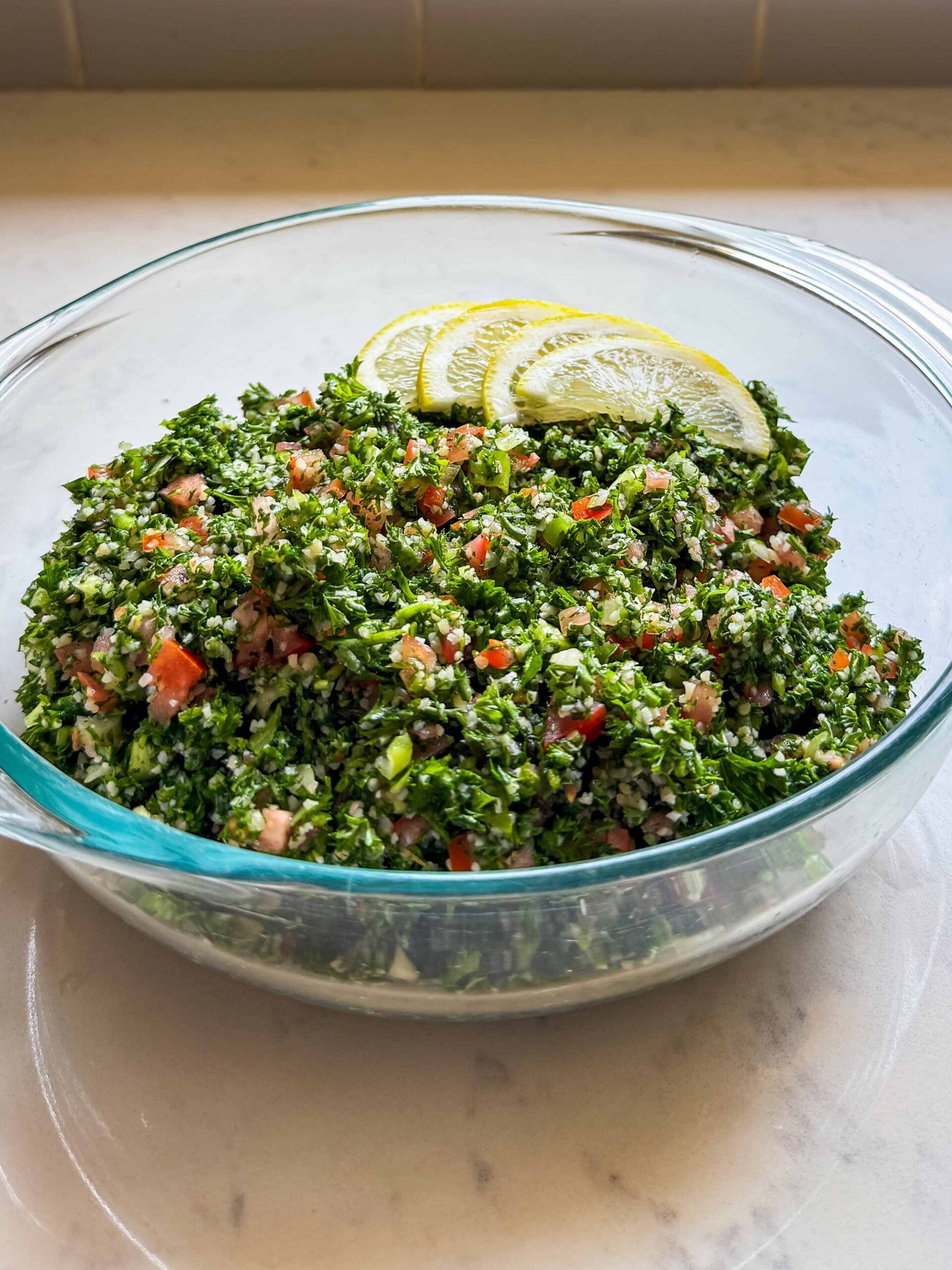 Bowl of homemade Levantine tabbouleh salad on a kitchen counter near a window