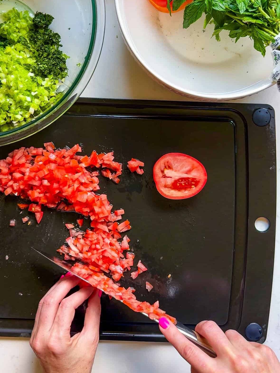 Finely chopping Roma tomatoes for homemade Levantine tabbouleh salad