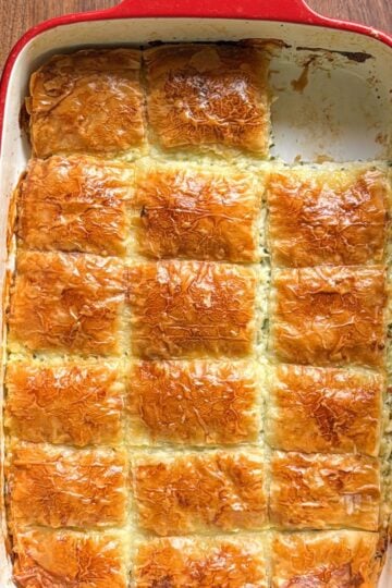 Armenian sheet cheese boreg baked golden and cut into squares in a red baking dish
