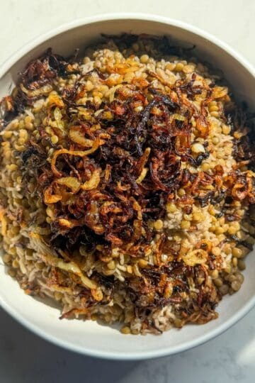 Top down view of a bowl of mujadara with lentils, rice, and browned onions
