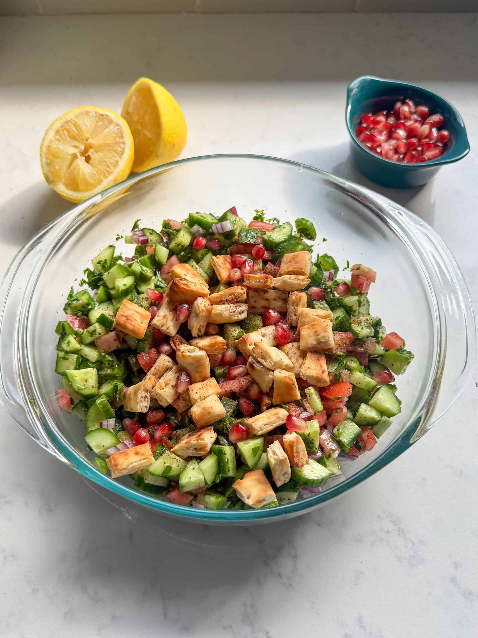 Finished Mediterranean chopped salad with sumac, served with fresh lemon