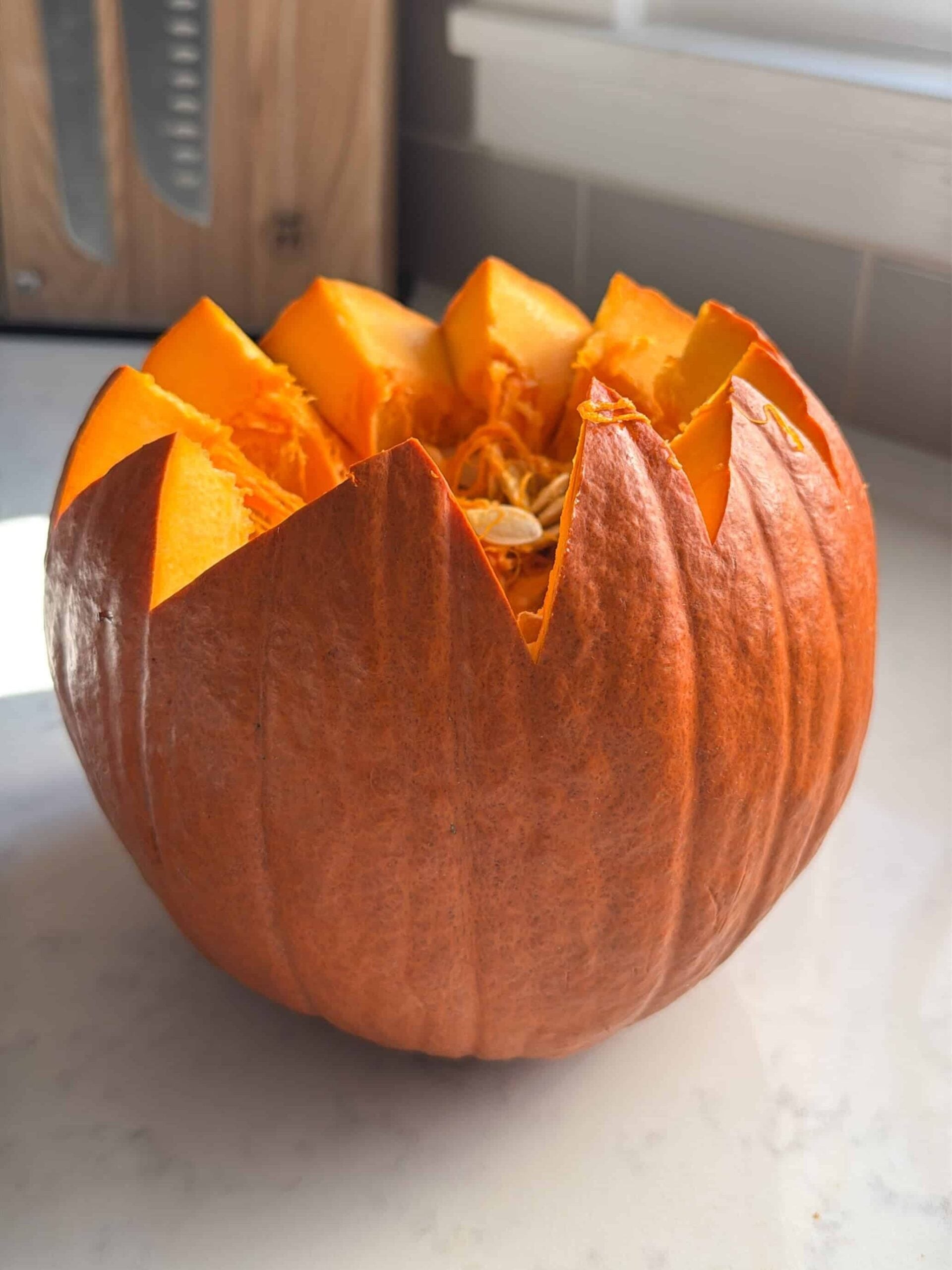 Pie pumpkin with a zigzag cut lid, ready to be cleaned out for ghapama