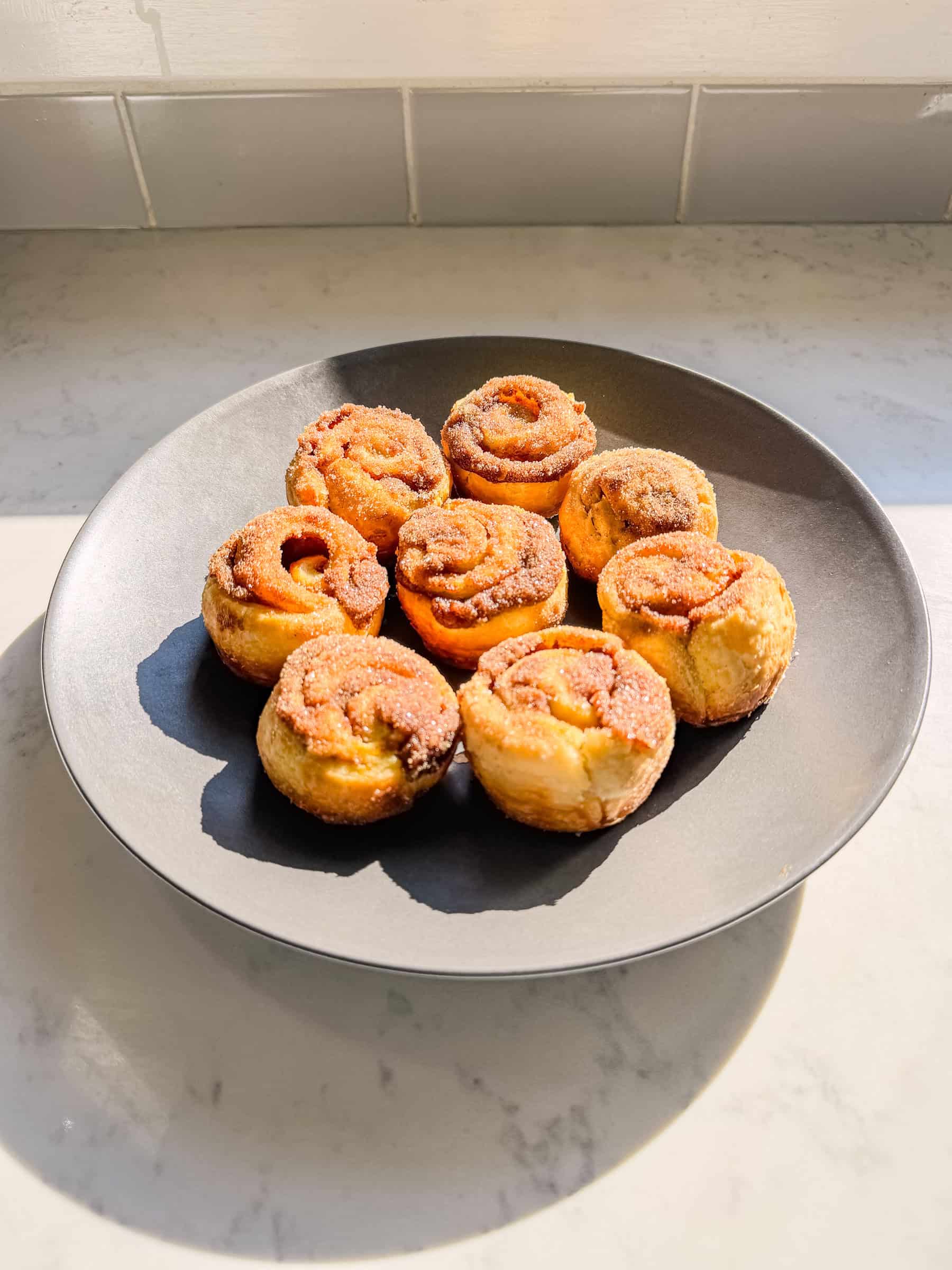 Platter of pumpkin spice cinnamon rolls on a kitchen counter for a fall breakfast